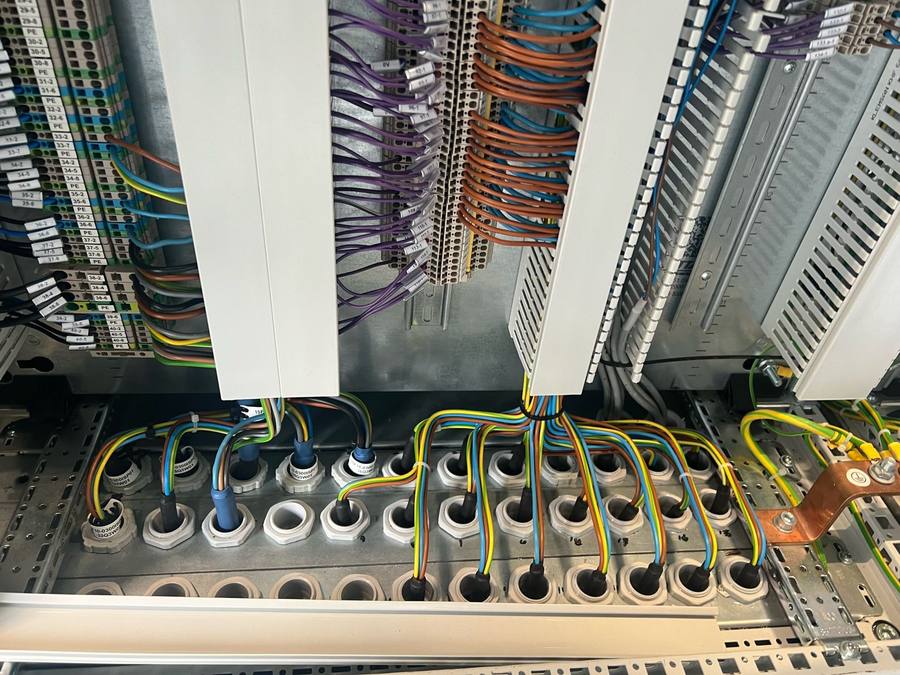Cables routed through cable glands in a cabinet base