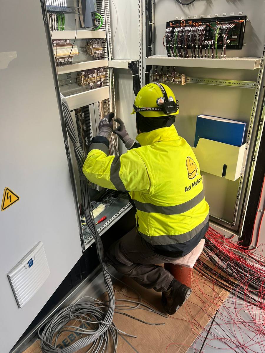 Worker wiring a control cabinet